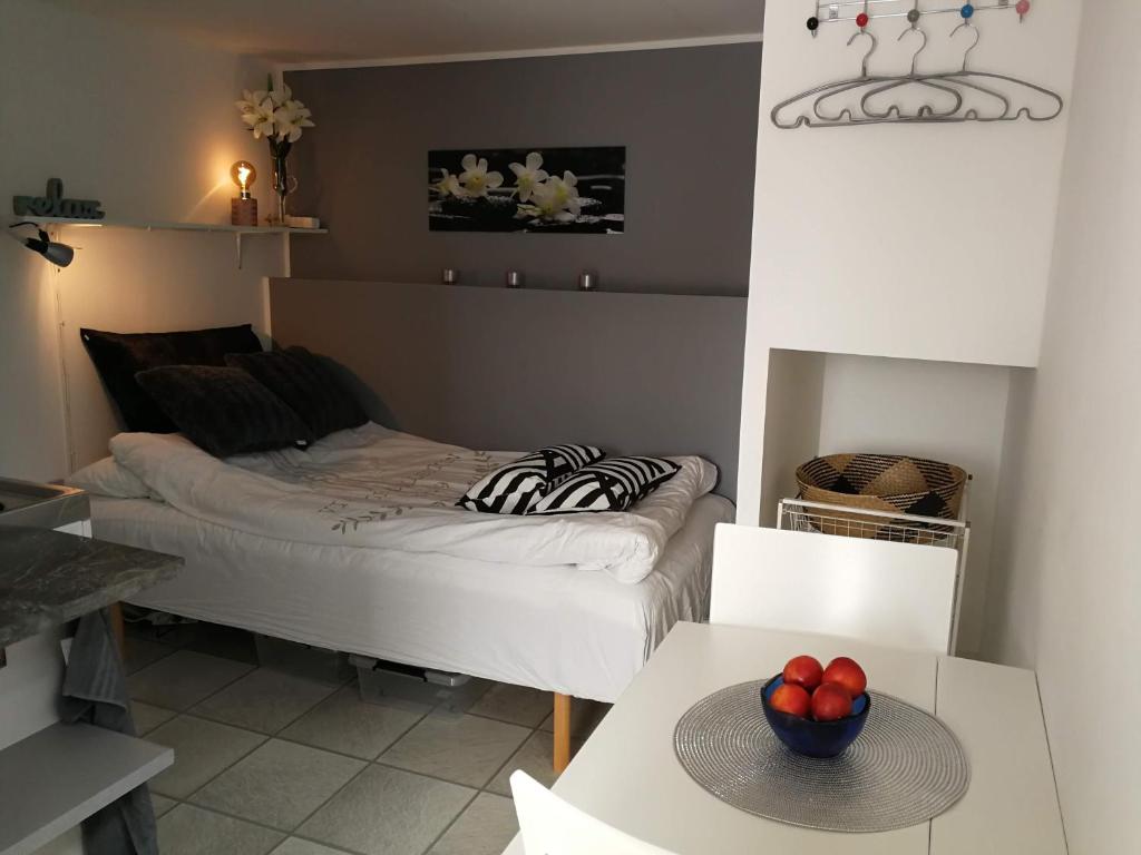 Una habitación con una cama y un bol de fruta en una mesa en Studio close to Malmö and Lund en Åkarp