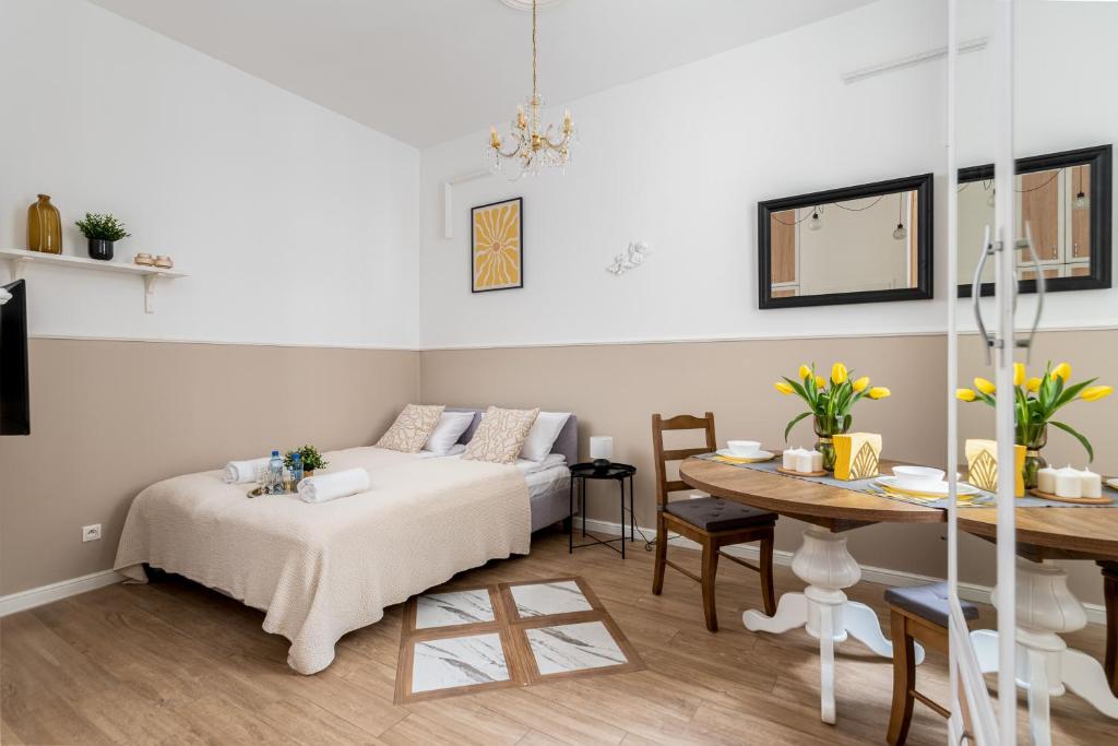 uma sala de estar com uma cama e uma mesa em Malila Premium Apartments City Center Kazimierz Starowiślna 41 em Cracóvia