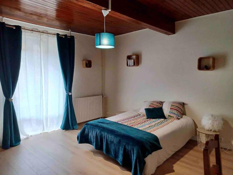 a bedroom with a bed and a large window at Maison familiale au cœur des Cabannes -montagne, rivière & découvertes in Les Cabannes