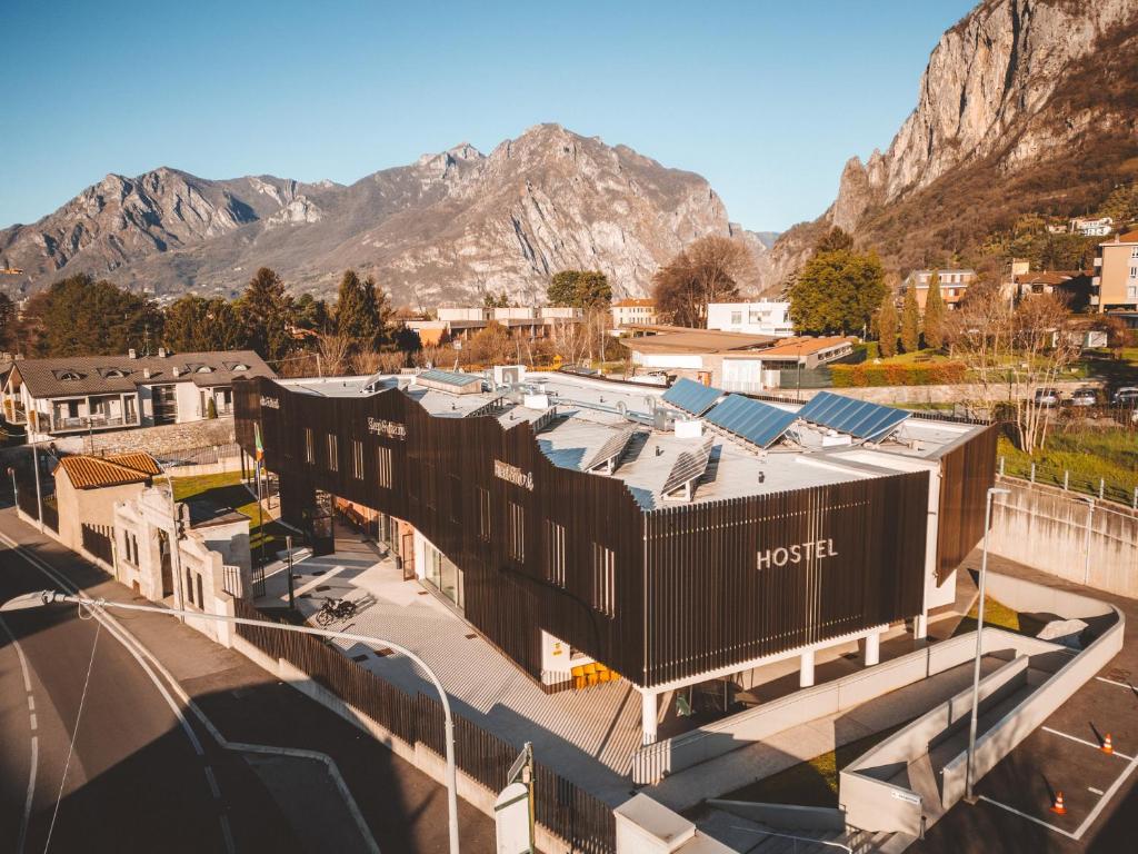 a rendering of a building with mountains in the background at Lecco Hostel & Rooms in Lecco