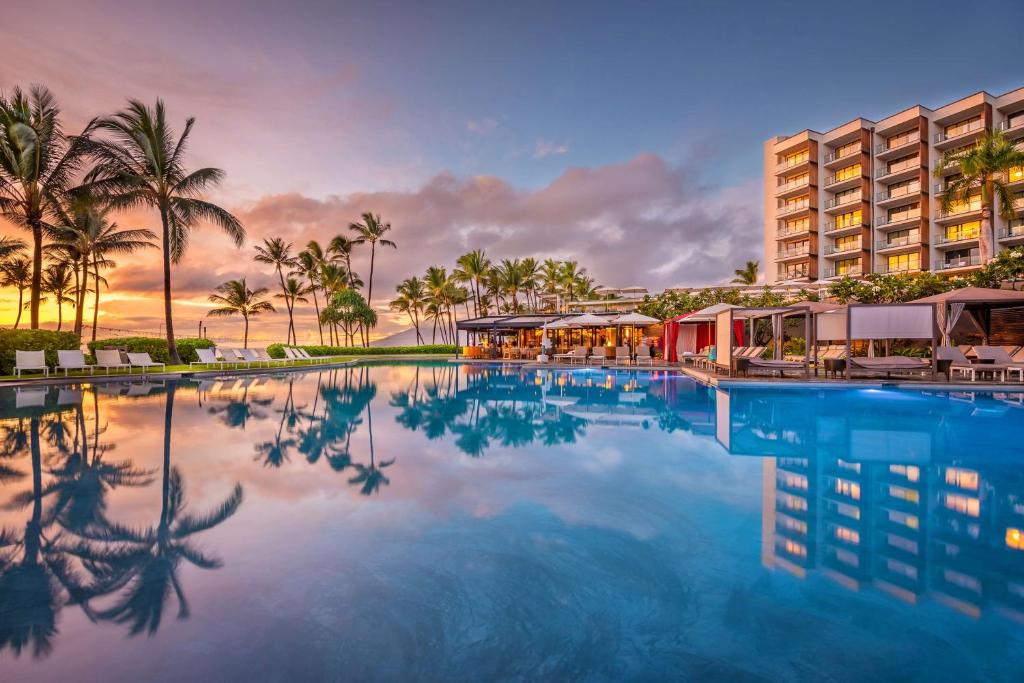 einen Pool in einem Resort mit Palmen und einem Gebäude in der Unterkunft Andaz Maui at Wailea Resort - A Concept by Hyatt in Wailea