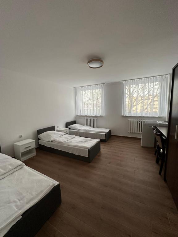 a large room with two beds and two windows at Zajazd Polonia in Kędzierzyn-Koźle