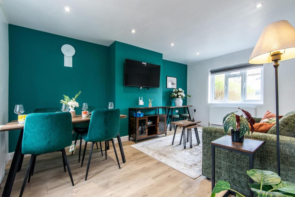 uma sala de estar com uma mesa e uma parede verde em 3 Bedroom Terraced House in Beeston Ideal for Corporate Stays em Beeston