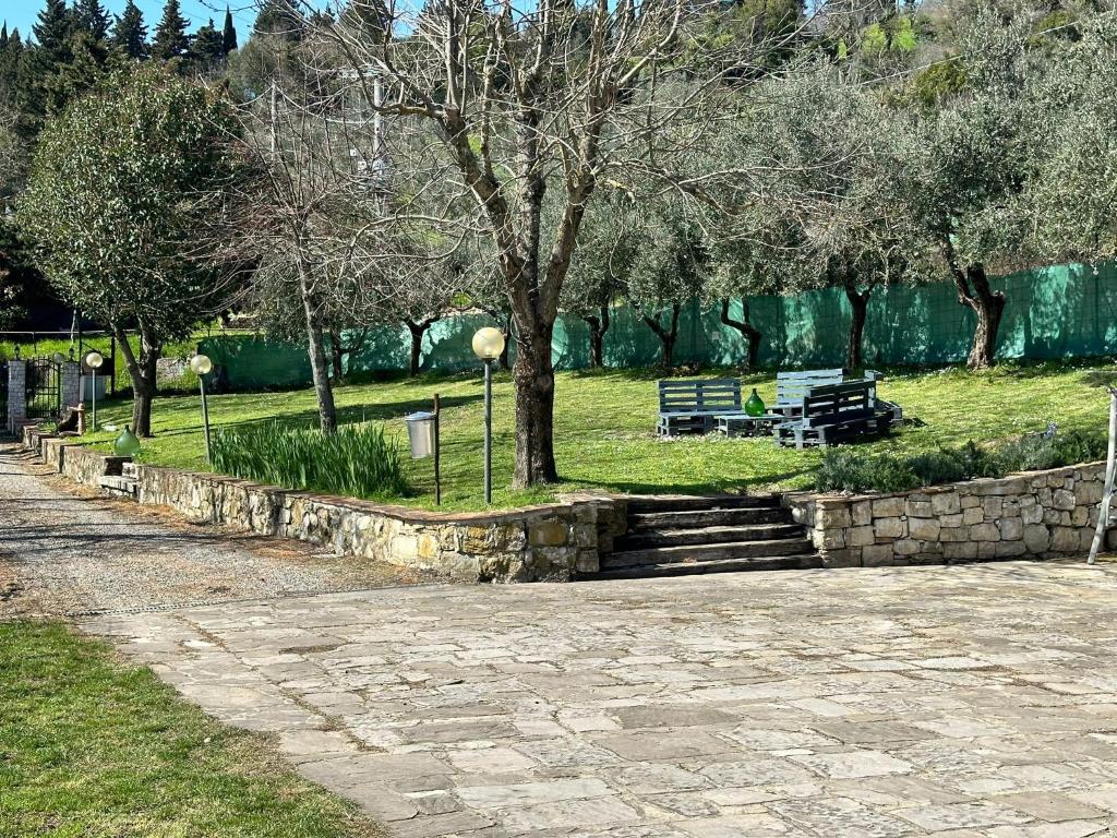 a park with a bench and stairs and trees at Agriturismo Tassinaia in Pontassieve