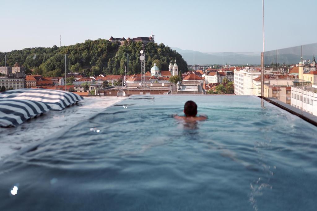 una persona en una piscina en la parte superior de un edificio en NEU RESIDENCES smart stay en Liubliana