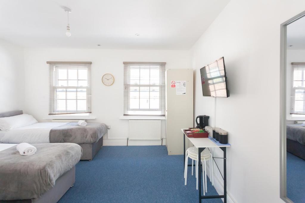 Kleines Zimmer mit 2 Betten und einem Tisch in der Unterkunft Budget City Center Apartment Aldgate - Tower Bridge in London