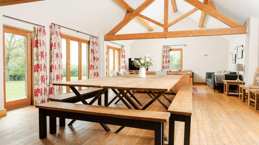 uma sala de jantar com uma mesa de madeira num quarto em Oak Tree Farm em Buxton