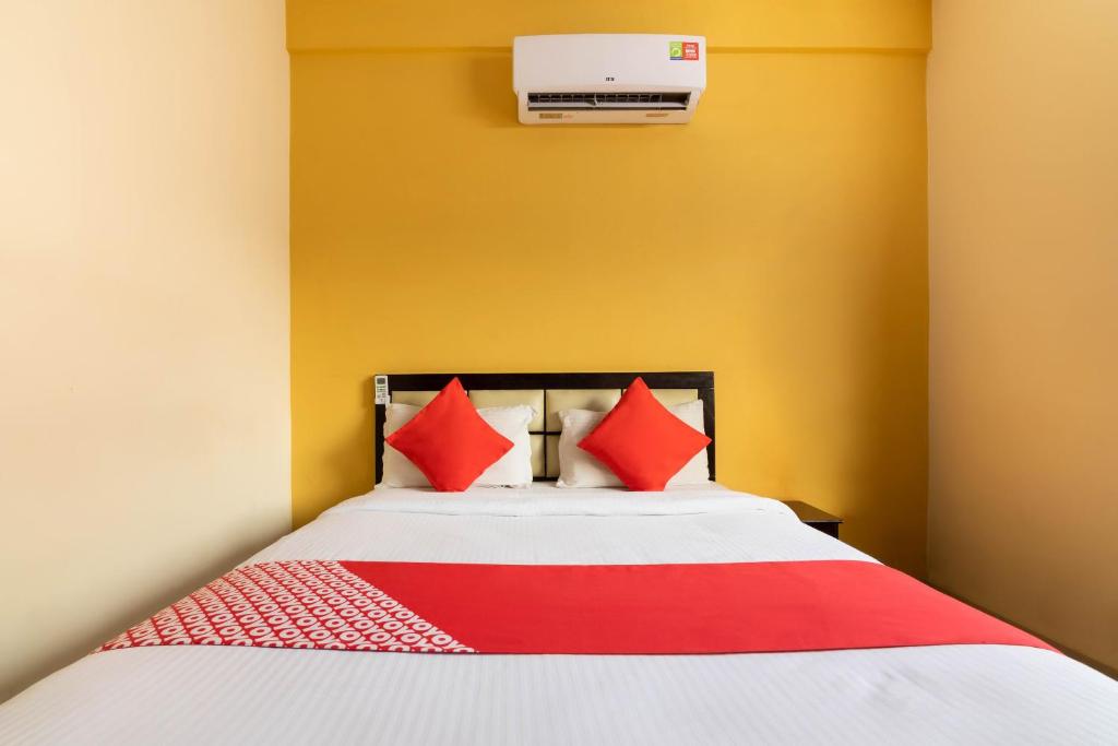 een slaapkamer met een bed met rode kussens bij OYO Hotel Royal INN Near Nexus Mall Koramangala in Bangalore