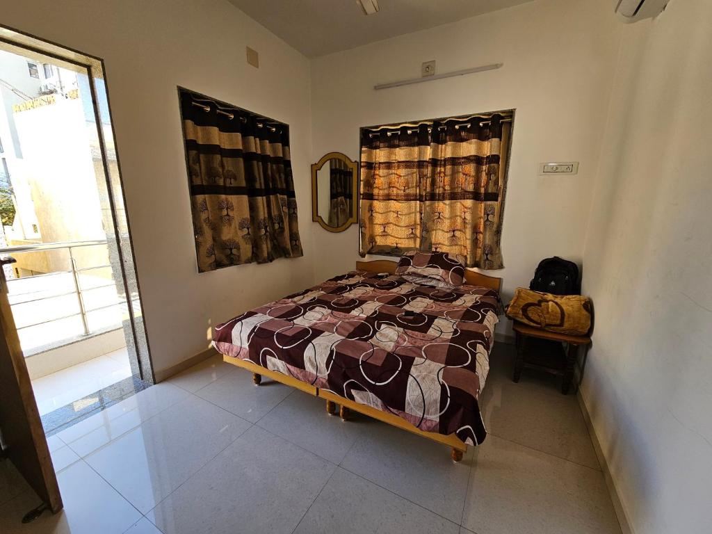 a bedroom with a bed and a window at Madhav Homestay in Dwarka