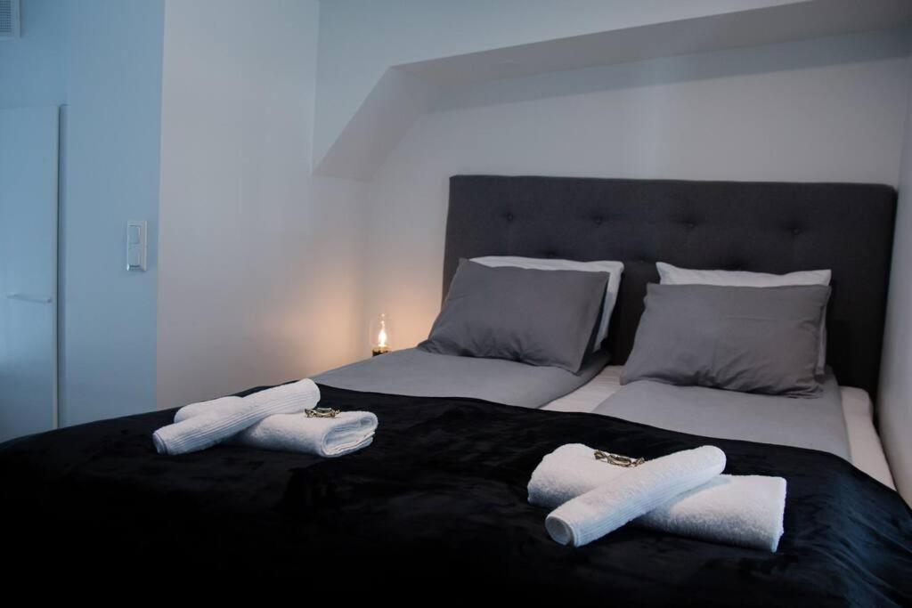 a bed with two towels on top of it at Elegant Penthouse Loft - Near the Airport in Vantaa