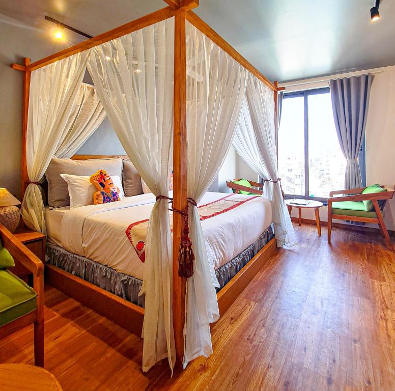 a bedroom with a canopy bed with a window at Hotel Nova Boutique in Rajkot
