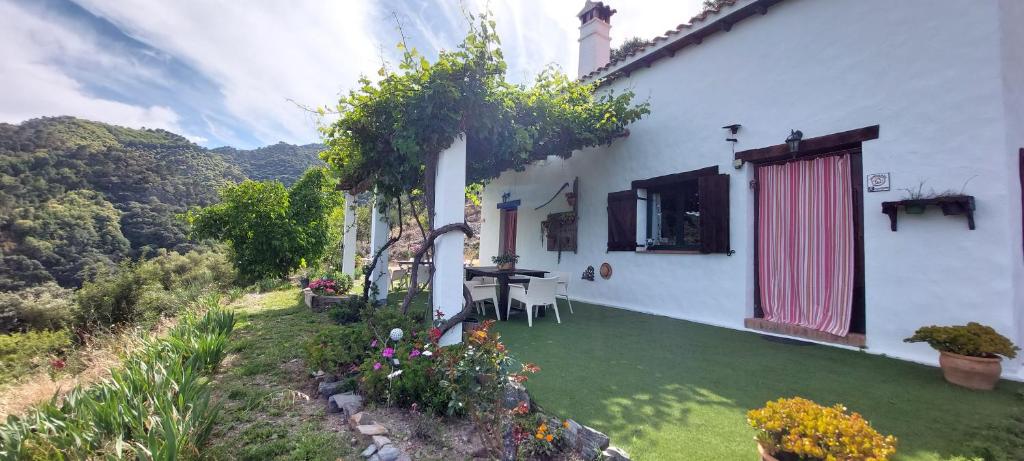 Casa blanca con patio con mesa y sillas en La Casa de la Era en Algatocín