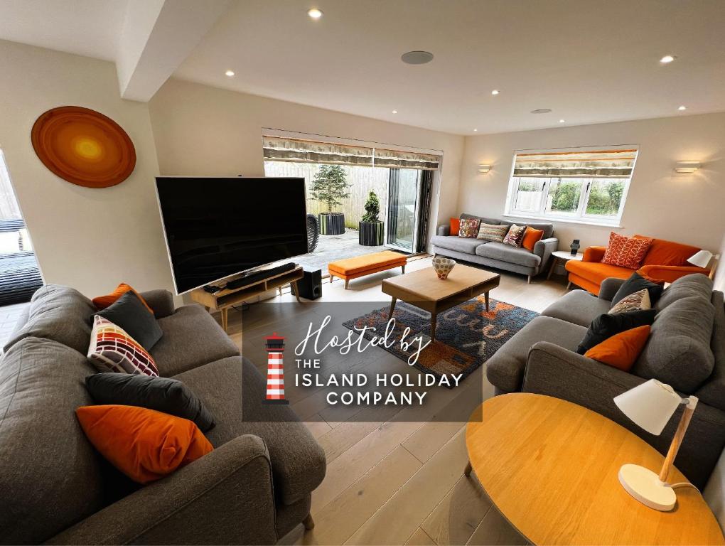 a living room with couches and a flat screen tv at Laurel Cottage in Sandown