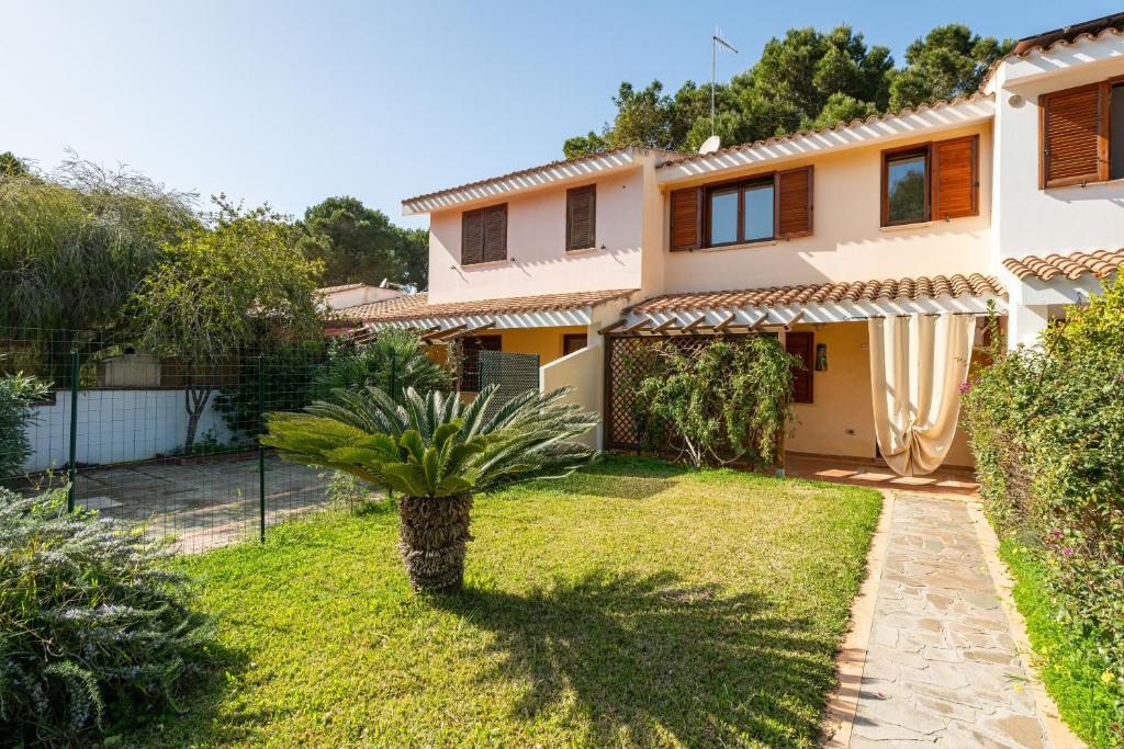 a house with a palm tree in the yard at Casa vacanze sole e mare in Porto Pino