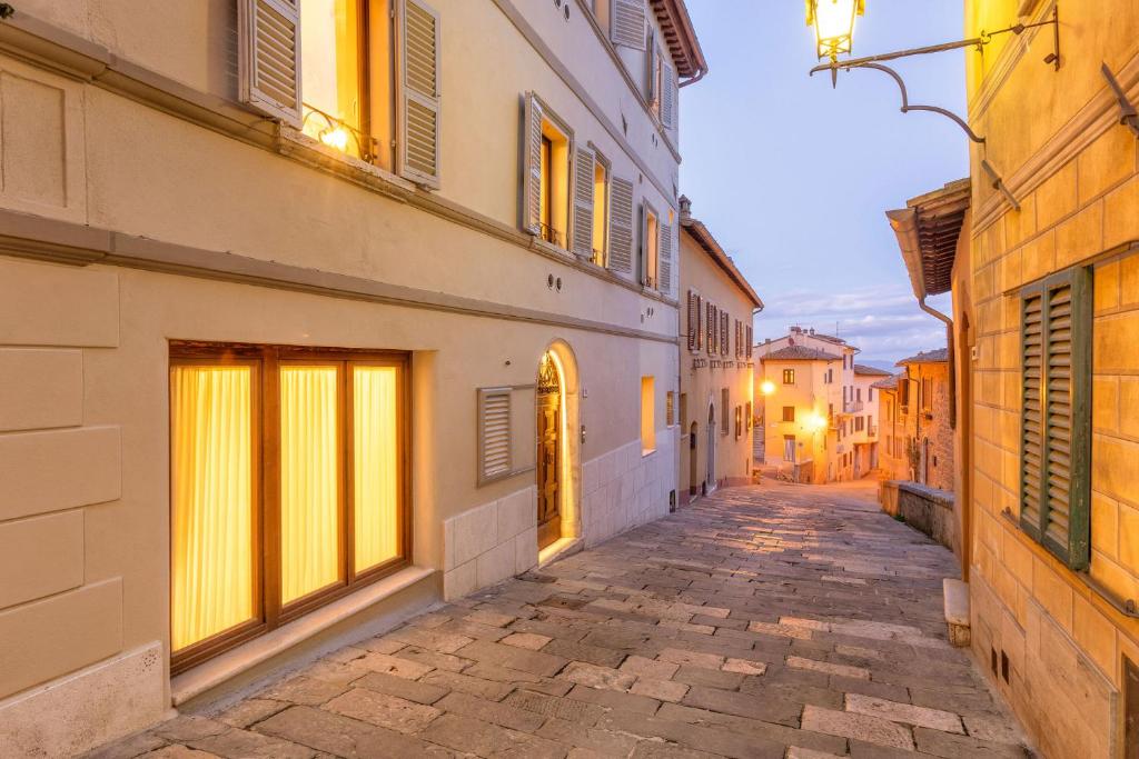 un callejón en un viejo pueblo al anochecer en Palazzo Falcinelli Luxury Room in Montepulciano Air Conditioning and Elevator en Montepulciano
