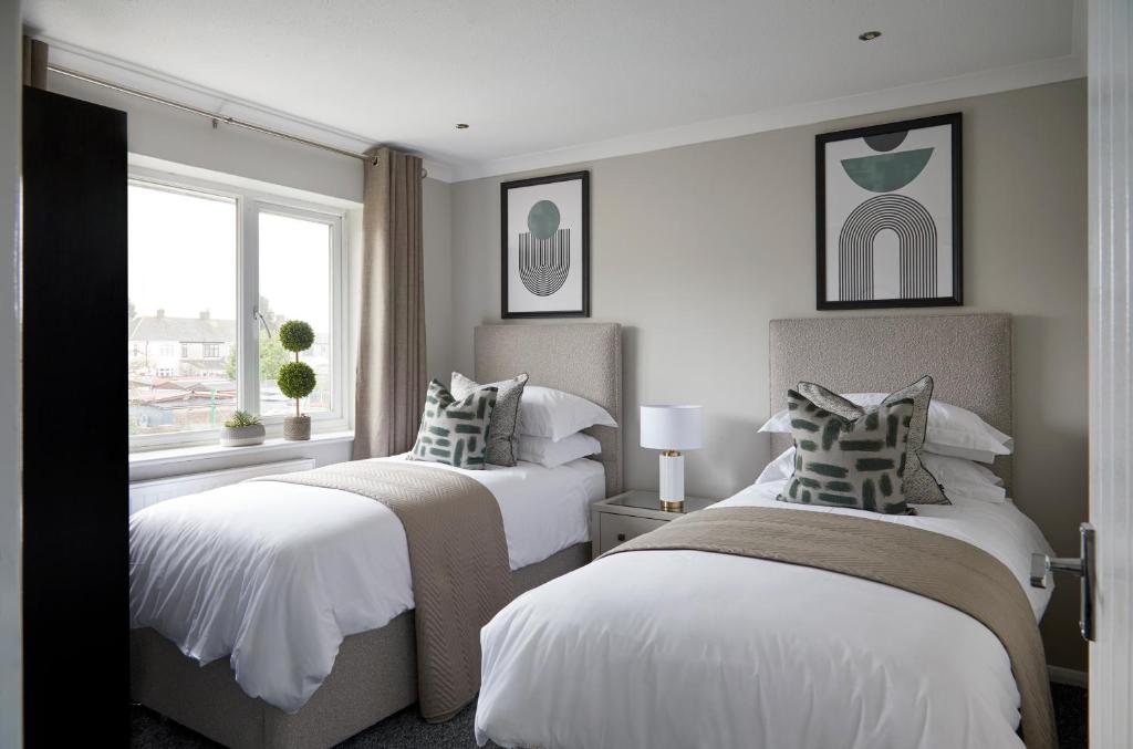 1 dormitorio con 2 camas y ventana en Cosy tastefully decorated flat in Rainham, en Rainham