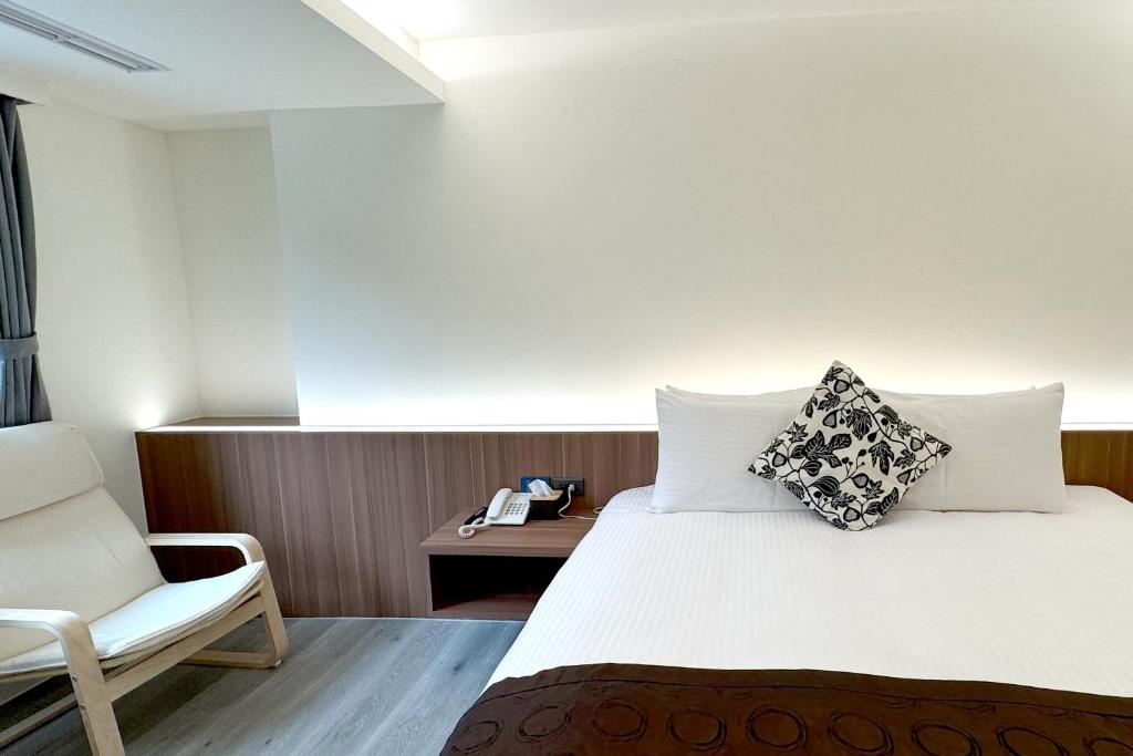 a hotel room with a bed and a chair at Dafong Hotel in Zhongzheng