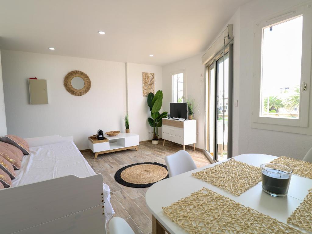 un salon blanc avec une table et un canapé dans l'établissement Studio cabine climatisé avec piscine et parking, accès direct à la plage - FR-1-753-17, à Saint-Cyprien