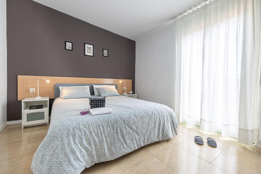 - une chambre avec un grand lit et une grande fenêtre dans l'établissement URBAN Center Apartments, à Tarragone