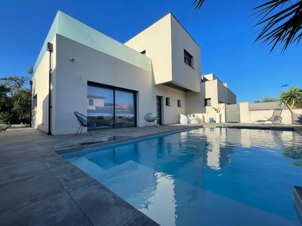 une piscine devant une maison dans l'établissement Superbe villa contemporaine avec piscine et climatisation - FR-1-776-82, à Argelès-sur-Mer