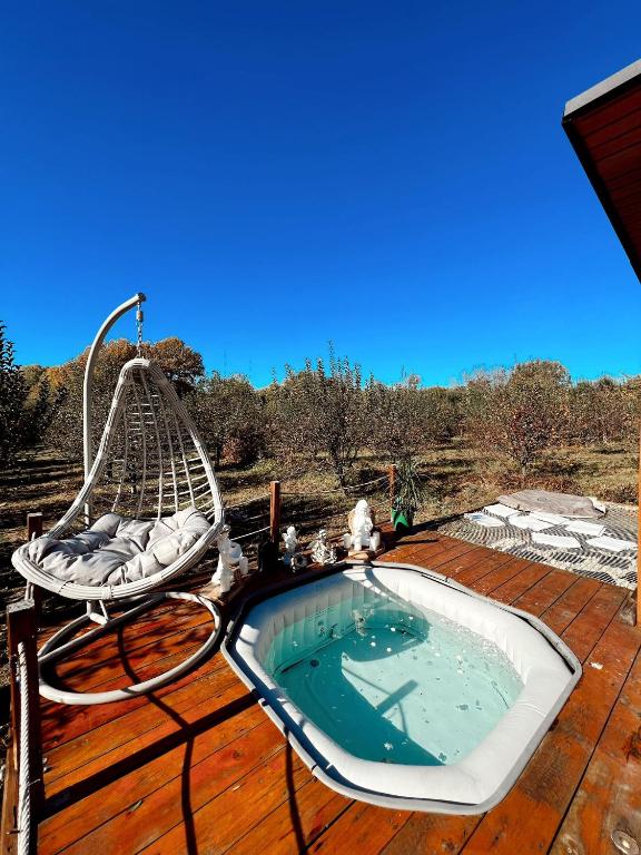a hot tub sitting on top of a wooden deck at Cuibul din livadă in Suduleni
