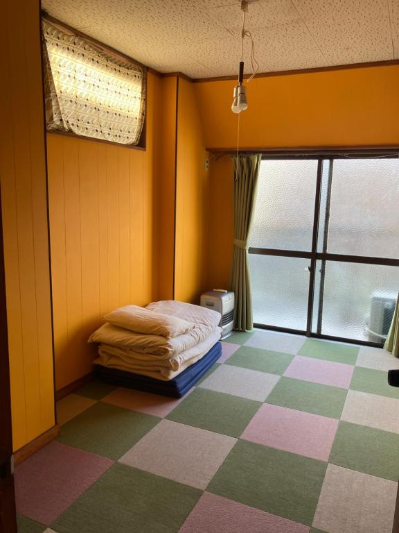 una camera con un letto e un pavimento a scacchi di 尾道ゲストハウス シータ村 a Onomichi