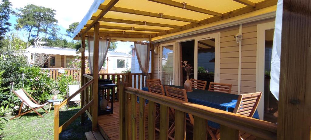 a wooden deck with a pergola on a house at Franck's tiny house in Lège-Cap-Ferret
