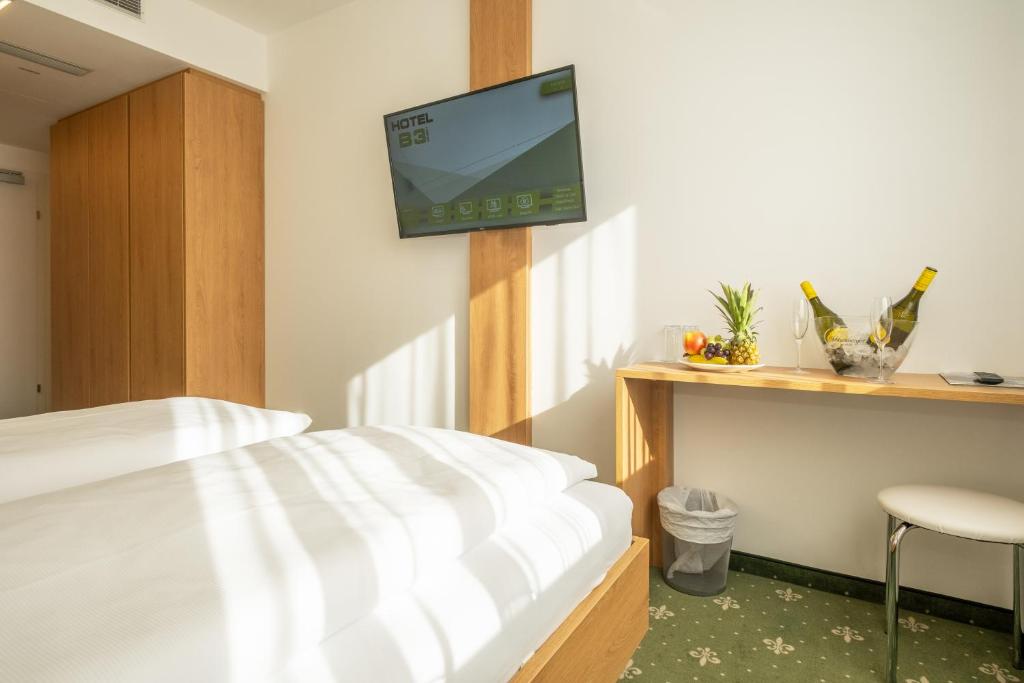 um quarto com uma cama e uma televisão na parede em Hotel B3 em Mauthausen