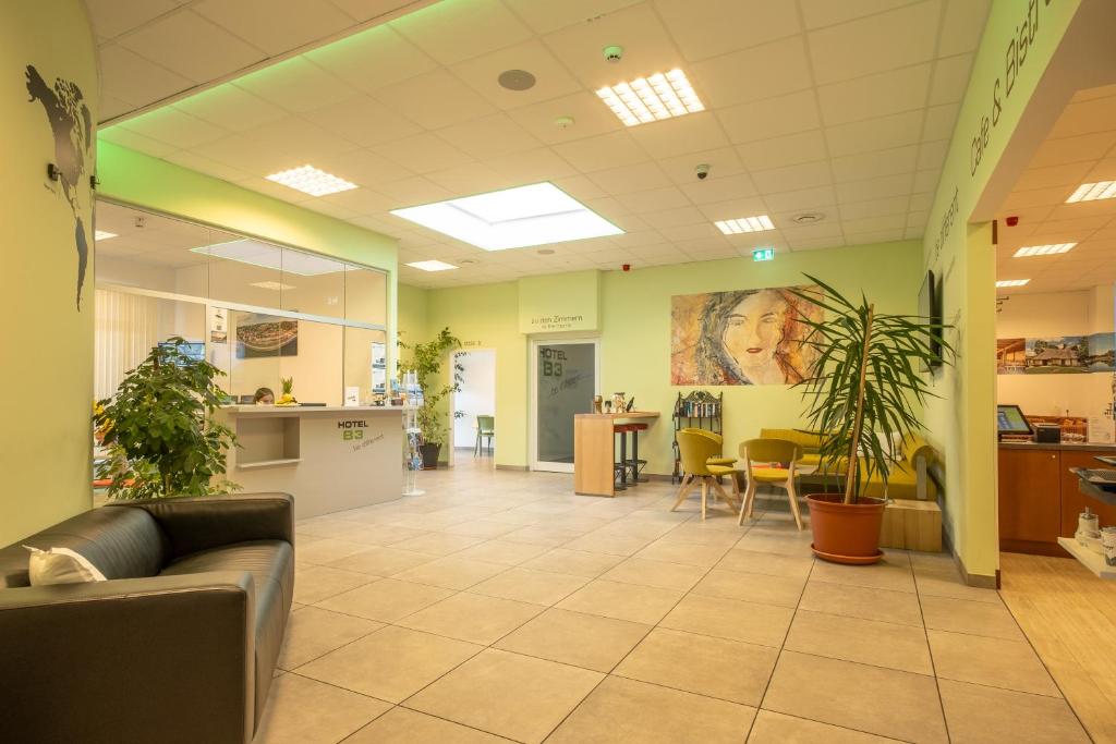 an office lobby with a couch and tables and chairs at Hotel B3 GmbH in Mauthausen