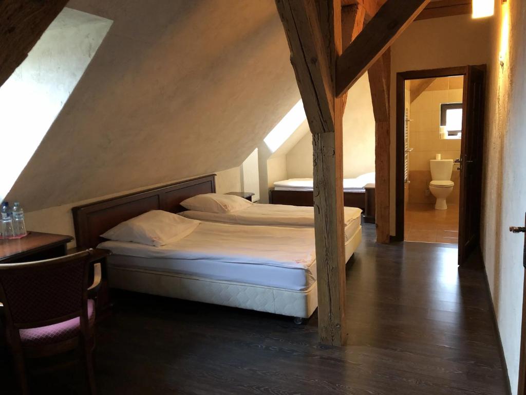 a bedroom with two beds in a attic at Folwark Polski in Ostrów Wielkopolski