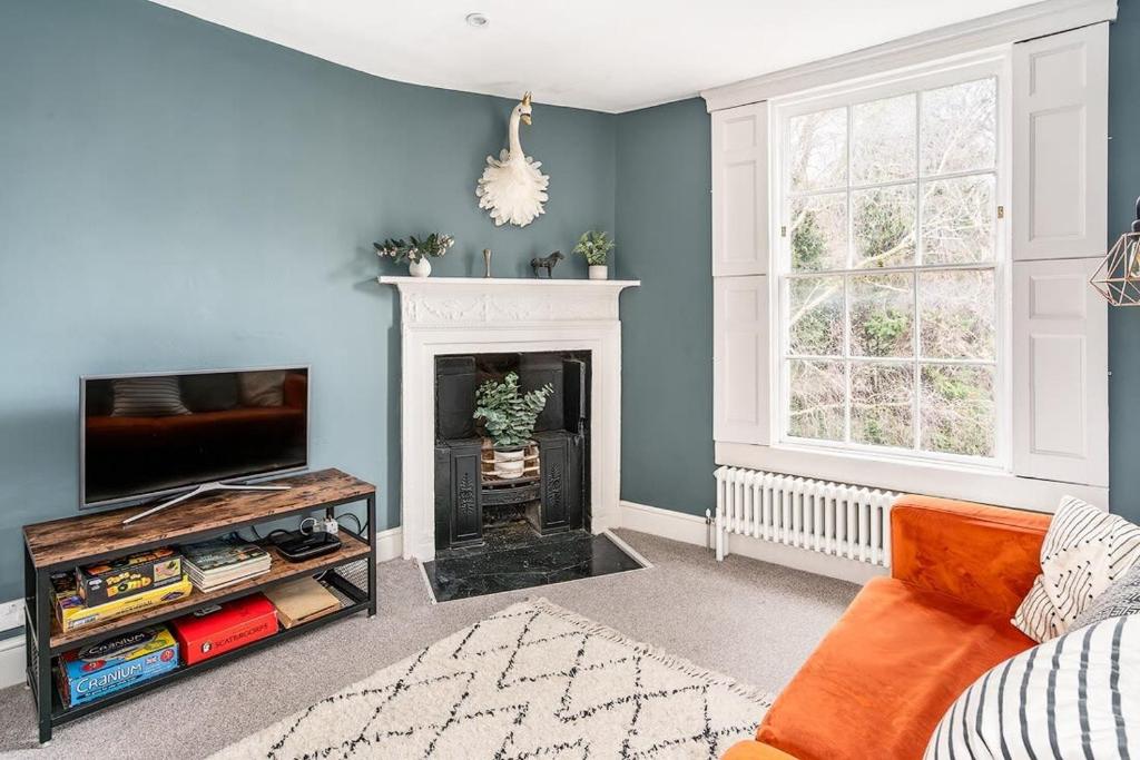 a living room with a television and a fireplace at Beautiful Central 2 Bed Flat in Bath