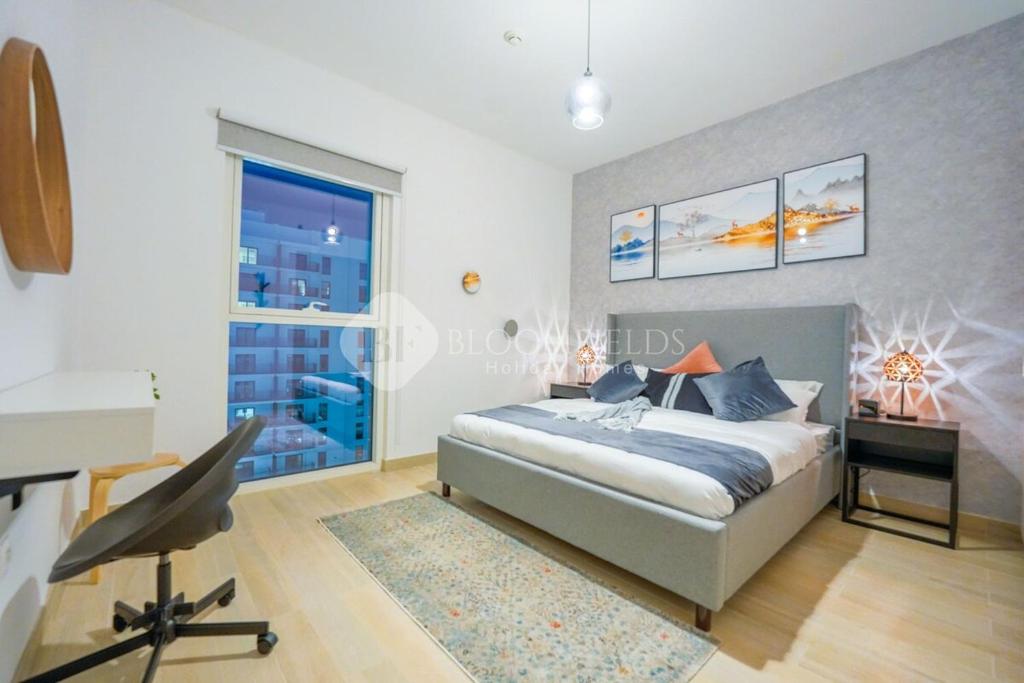 a bedroom with a bed and a desk and a window at Cozy 1 Bedroom Home In Yas Island in Abu Dhabi