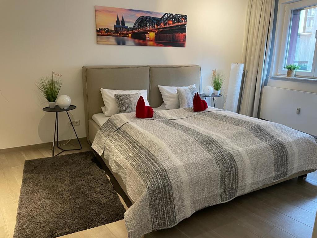 ein Schlafzimmer mit einem großen Bett mit roten Kissen in der Unterkunft FlatDeCologne VeeDel in Köln