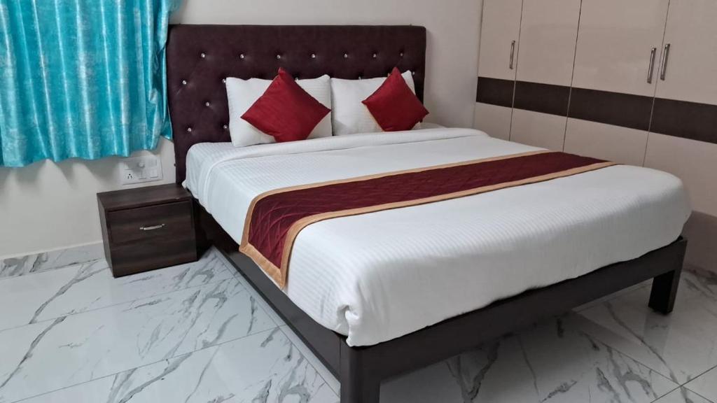 een slaapkamer met een groot bed met rode kussens bij 7HILLSHOMESTAY in Tirupati