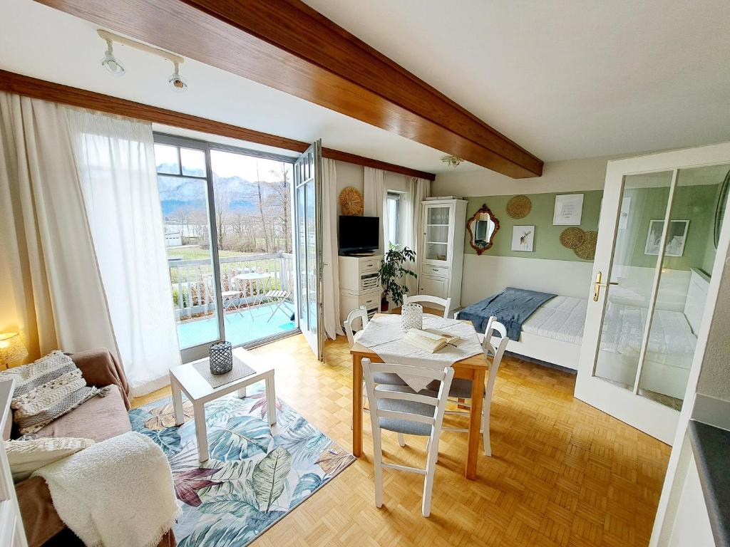 a living room with a room with a bed and a table at Ferienwohnung "Glücksplatzerl" in Mondsee