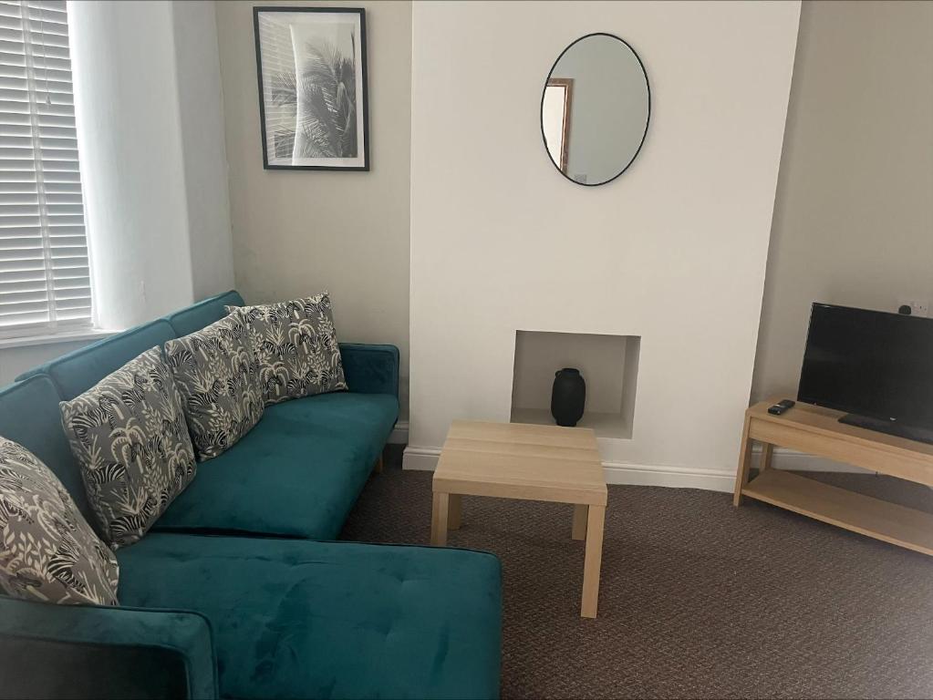 a living room with a blue couch and a table at Dunhill Townhouse in Goole