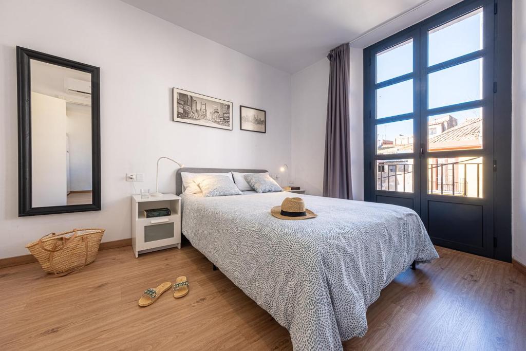 a bedroom with a bed with a hat on it at Tarragona Apartments in Tarragona