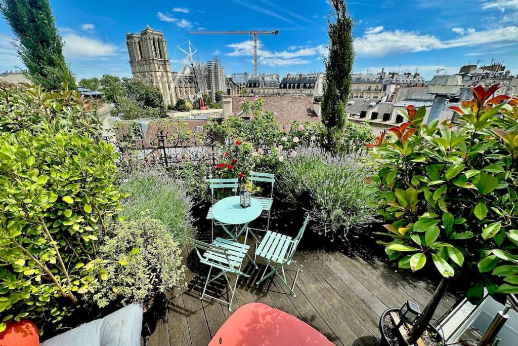 a patio with a table and chairs and plants at Rooftop Triplex with Garden at Notre Dame in Paris