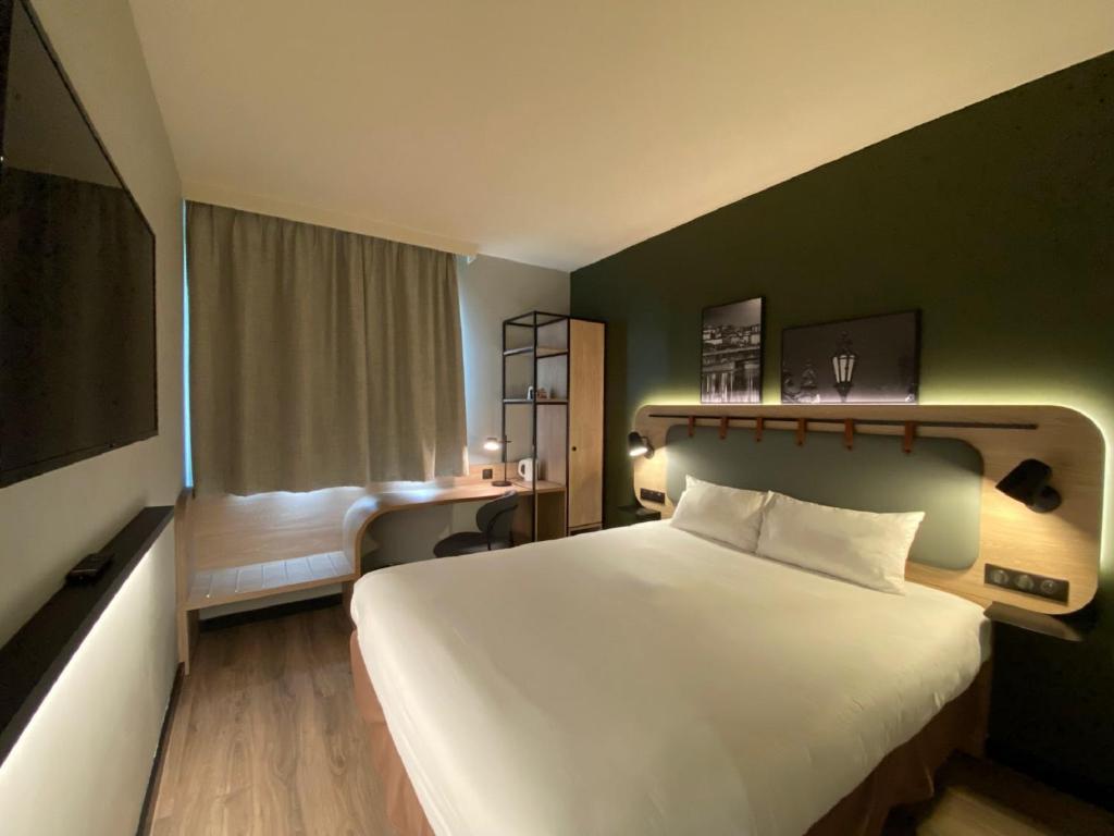 una habitación de hotel con una gran cama blanca y una ventana en Campanile Lyon Centre Part-Dieu, en Lyon