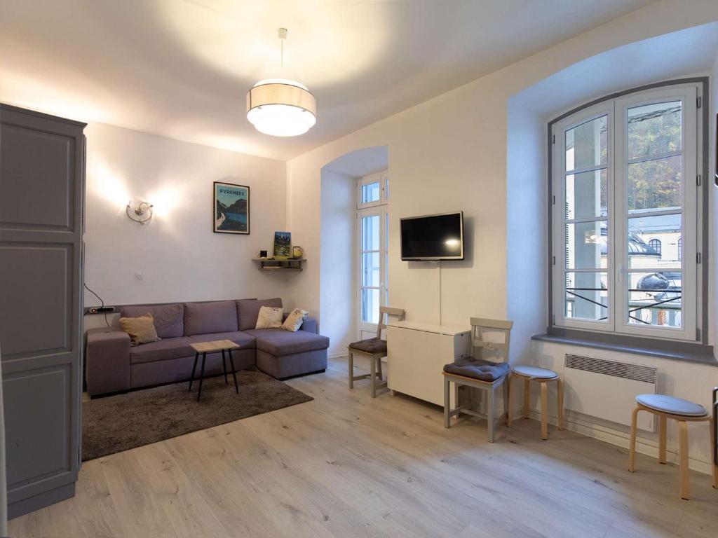 un salon avec un canapé et une télévision dans l'établissement Studio cosy rénové au centre de Cauterets, idéal pour 4, équipé et confortable - FR-1-401-283, à Cauterets