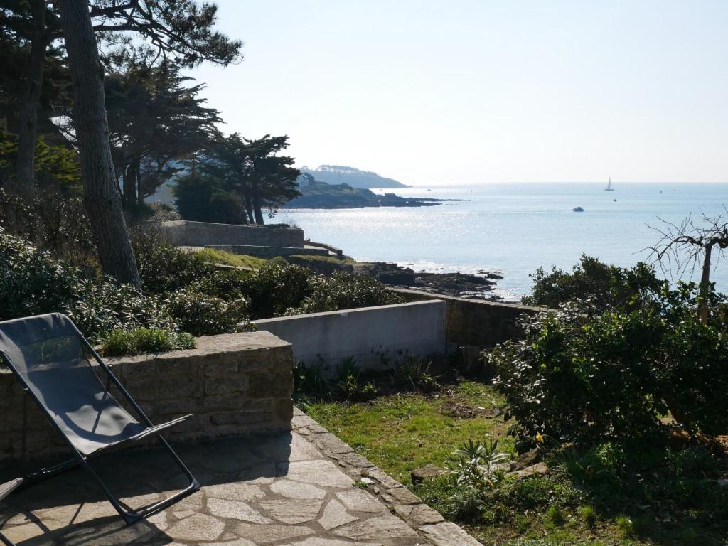 a chair sitting on a path near the ocean at Maison Arzon, 6 pièces, 11 personnes - FR-1-639-29 in Arzon