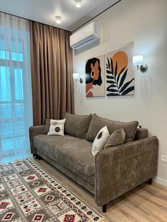 a living room with a brown couch and a rug at A-Six Apartment luxury in Karagandy