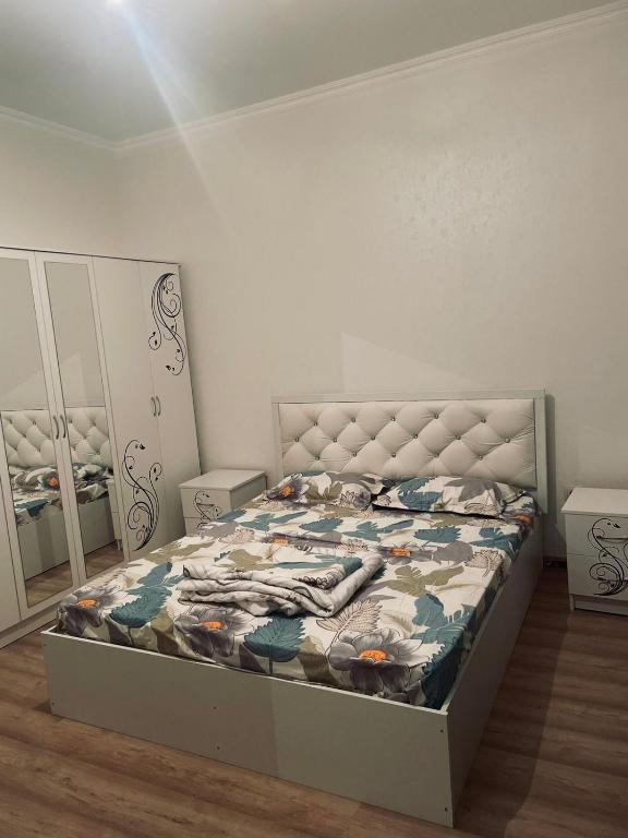um quarto com uma cama e um espelho em ЖК Кокжайлау em Shymkent