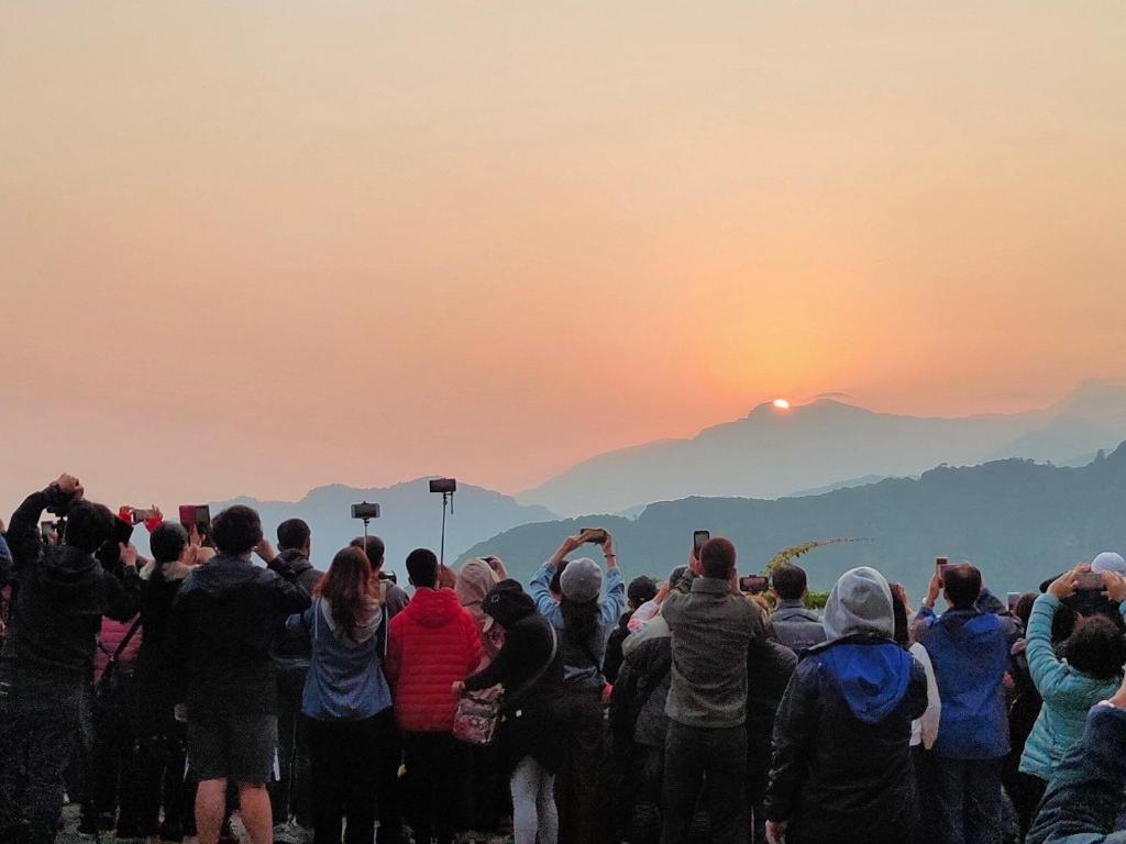 a crowd of people standing on a mountain watching the sunset at Dafong Hotel in Zhongzheng