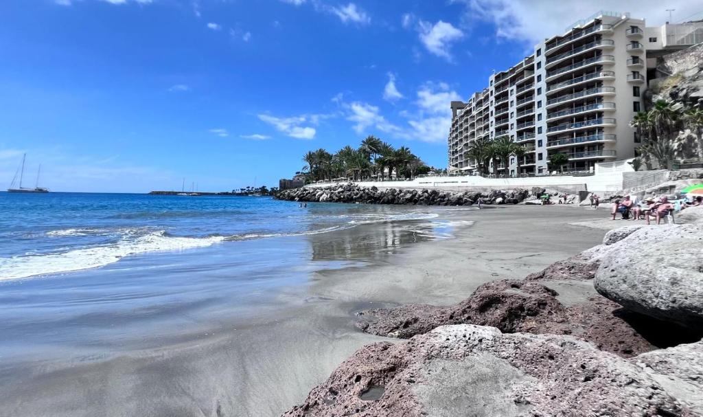 une plage de rochers en face d'un bâtiment dans l'établissement Apartamento-Estudio en la Playa, à Patalavaca