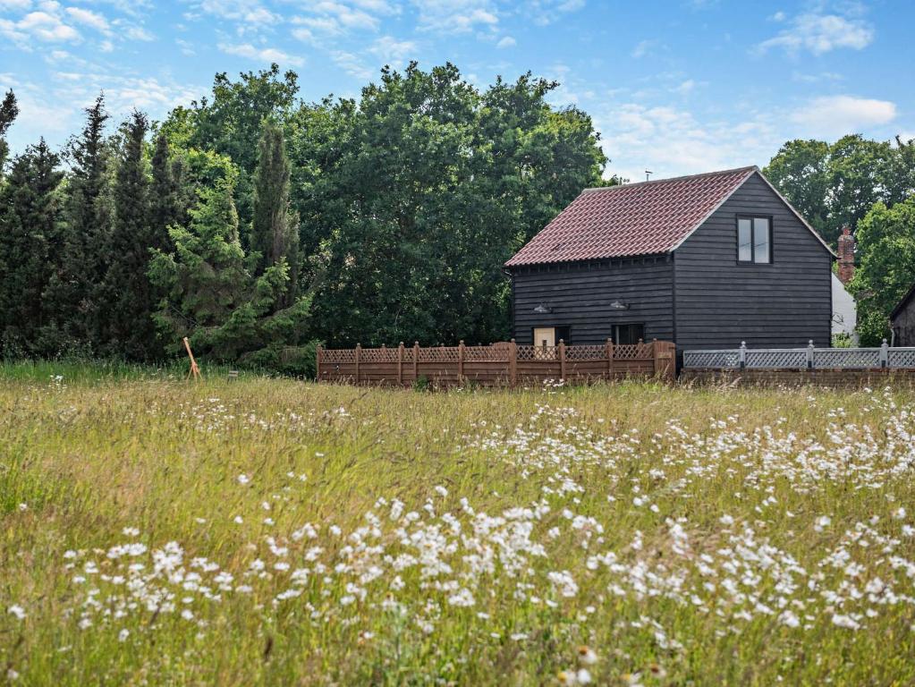 a black barn in the middle of a field of flowers at 1 Bed in Wix 92565 in Wix