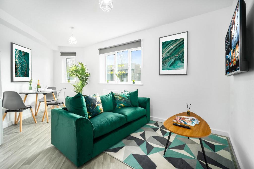 uma sala de estar com um sofá verde e uma mesa em 2 Bedroom Deluxe Apartment - Secure Parking - Wifi - Netflix - 27C em Sleightholme