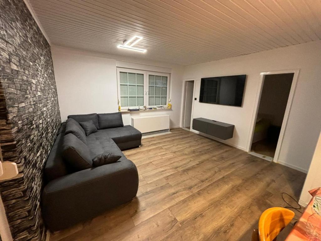 a living room with a couch and a flat screen tv at Ferienhaus Friesenengel in Dornumersiel