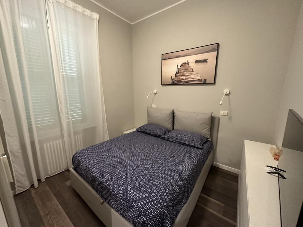 ein kleines Schlafzimmer mit einem Bett und einem Bild an der Wand in der Unterkunft Nuovo Appartamento Borgo Coscia in Alassio