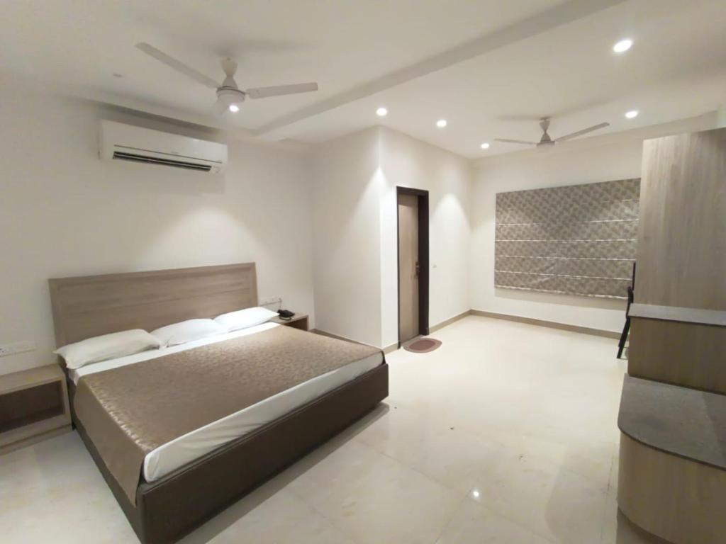een slaapkamer met een bed in een kamer bij BAGLA ATITHI BHAWAN in Varanasi